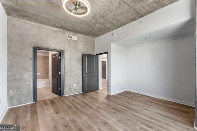 unfurnished bedroom with visible vents, baseboards, and wood finished floors