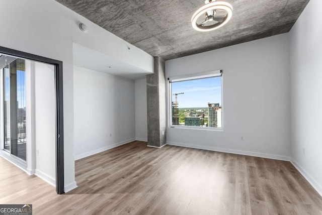 spare room featuring baseboards and wood finished floors