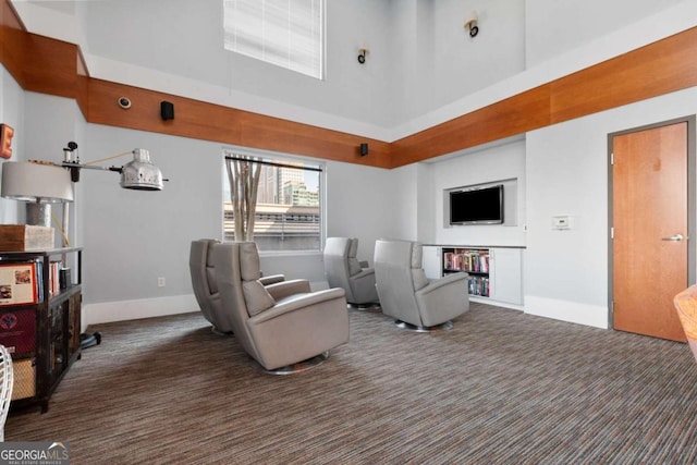 carpeted living room featuring a high ceiling and baseboards