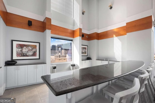 dining room with a towering ceiling and light tile patterned floors