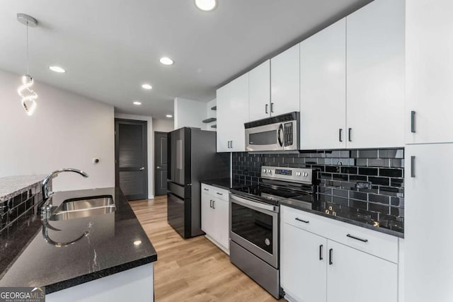 kitchen featuring stainless steel appliances, light wood-style flooring, a sink, tasteful backsplash, and recessed lighting