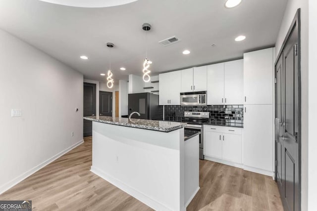 kitchen with white cabinets, tasteful backsplash, visible vents, and appliances with stainless steel finishes