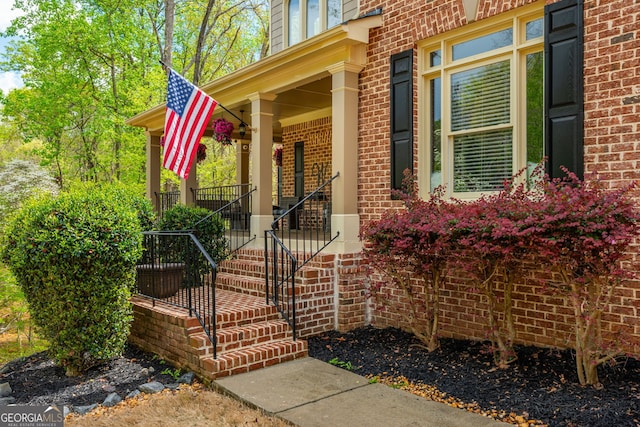 entrance to property featuring brick siding and a porch