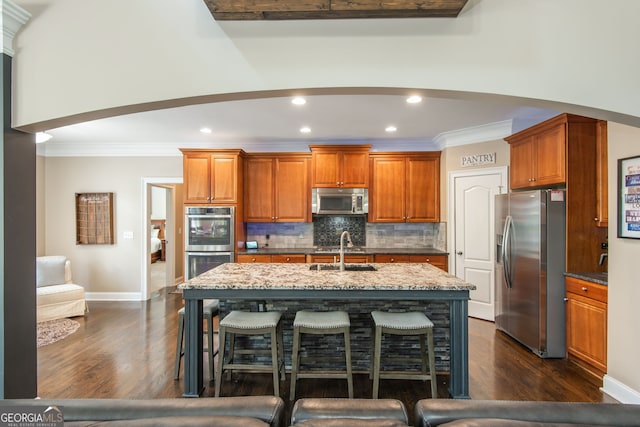 kitchen with dark wood-style flooring, a sink, ornamental molding, and appliances with stainless steel finishes