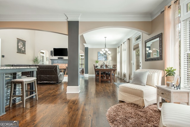 interior space featuring arched walkways, a healthy amount of sunlight, dark wood-style floors, and a brick fireplace