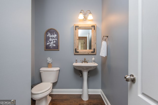 bathroom featuring toilet, wood finished floors, and baseboards