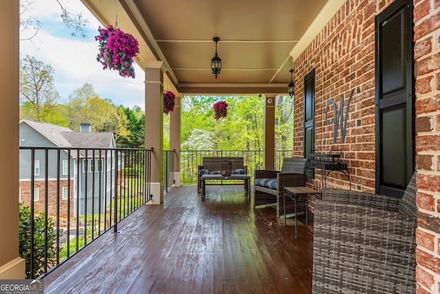 wooden terrace featuring outdoor lounge area and covered porch