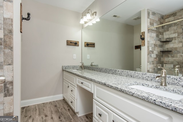 bathroom with visible vents, a sink, toilet, and wood finished floors