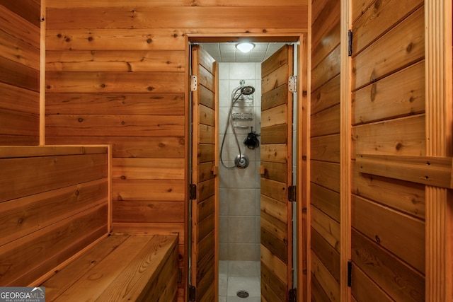 full bathroom featuring wood walls and a stall shower