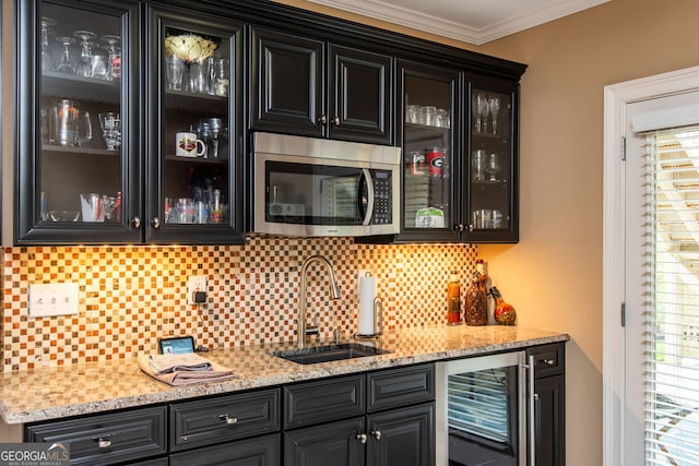 bar with indoor wet bar, a sink, wine cooler, stainless steel microwave, and decorative backsplash