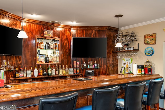 bar featuring crown molding, wet bar, pendant lighting, and visible vents