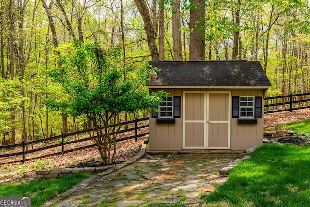 view of shed featuring a forest view and a fenced backyard