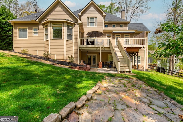 rear view of house featuring a patio, a chimney, french doors, a yard, and a deck