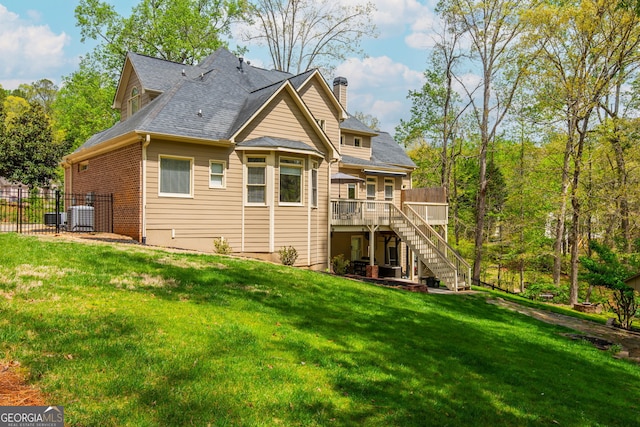 back of house featuring central AC unit, a yard, a chimney, stairway, and a wooden deck