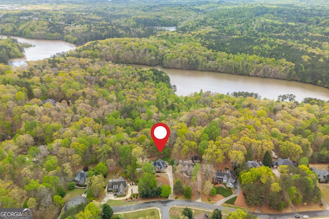 birds eye view of property with a wooded view and a water view