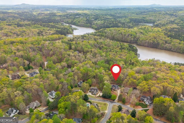 birds eye view of property with a water view and a view of trees