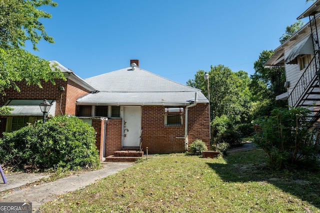 738 Liberty St, Macon, GA 31201 - view of front of property with a front yard, brick siding, a chimney, and entry steps