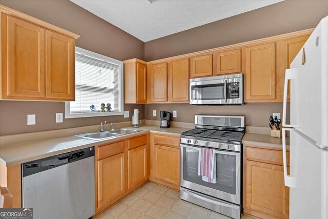 200 Arrowhead Ln, Canton, GA 30114 - kitchen featuring light floors, light brown cabinetry, appliances with stainless steel finishes, a sink, and light countertops