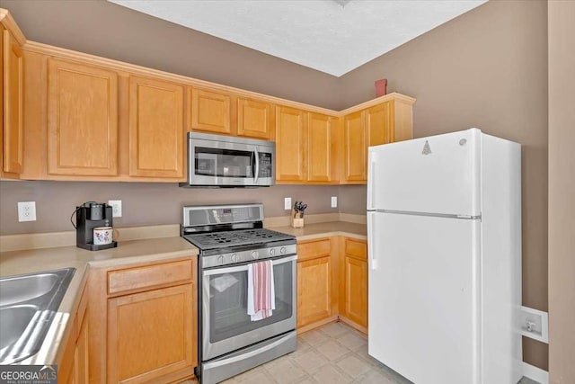 200 Arrowhead Ln, Canton, GA 30114 - kitchen with a sink, light countertops, light brown cabinetry, stainless steel appliances, and light floors