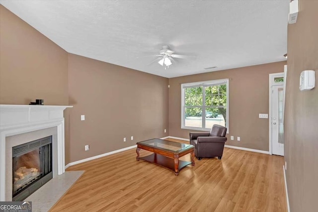 200 Arrowhead Ln, Canton, GA 30114 - living room with light wood finished floors, a fireplace with flush hearth, ceiling fan, and baseboards