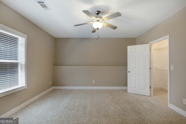 spare room with carpet, ceiling fan, and baseboards