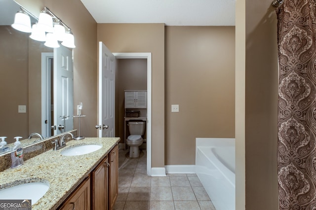 full bath featuring tile patterned flooring, toilet, baseboards, double vanity, and a tub to relax in