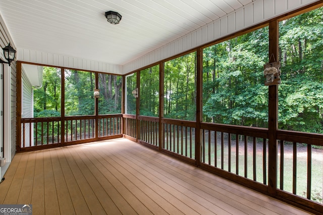 unfurnished sunroom featuring a water view