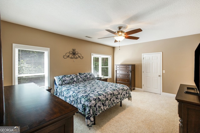 bedroom featuring light carpet, a ceiling fan, and baseboards