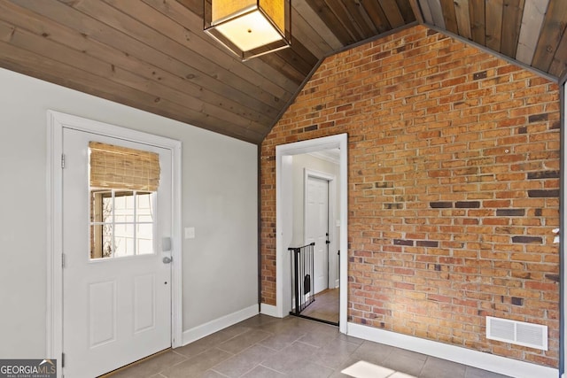 interior space featuring brick wall, visible vents, and vaulted ceiling
