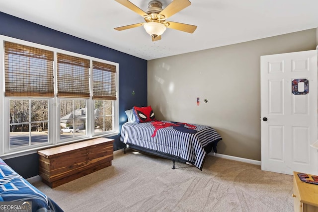 carpeted bedroom featuring baseboards and a ceiling fan