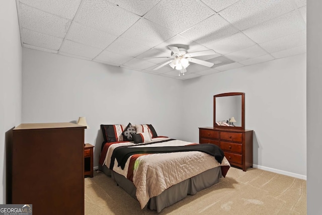 bedroom featuring light carpet, a paneled ceiling, baseboards, and a ceiling fan