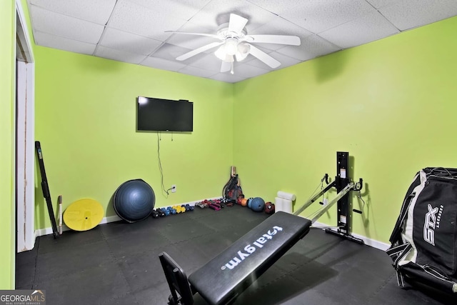 exercise room featuring baseboards, a drop ceiling, and ceiling fan