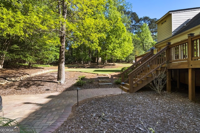 view of yard with a patio area, a wooden deck, and stairway