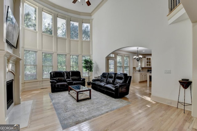 1806 Royal Troon Ct, Duluth, GA 30097 - living area with a towering ceiling, a chandelier, arched walkways, a high end fireplace, and a ceiling fan