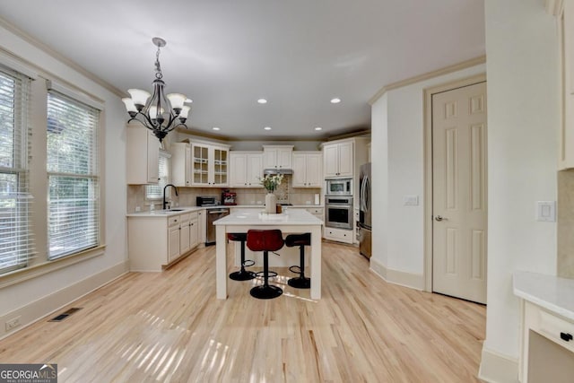 1806 Royal Troon Ct, Duluth, GA 30097 - kitchen featuring stainless steel appliances, a breakfast bar, decorative backsplash, light countertops, and recessed lighting