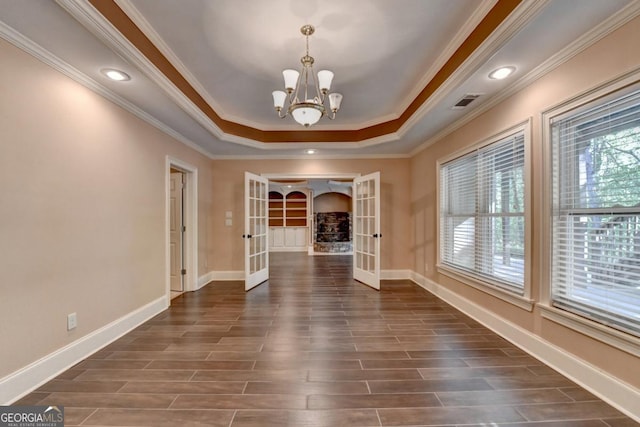 1806 Royal Troon Ct, Duluth, GA 30097 - empty room with french doors, a tray ceiling, ornamental molding, a chandelier, and dark wood-style floors