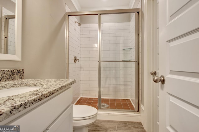 full bathroom featuring toilet, a stall shower, vanity, and crown molding