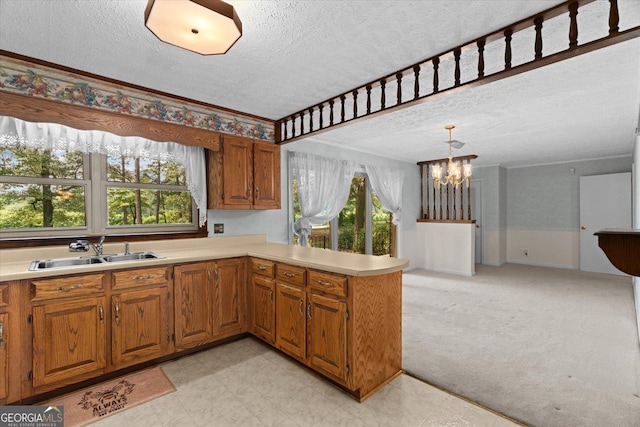 1070 Lovers Lane Rd SE, Calhoun, GA 30701 - kitchen featuring a sink, a textured ceiling, light countertops, a chandelier, and brown cabinetry