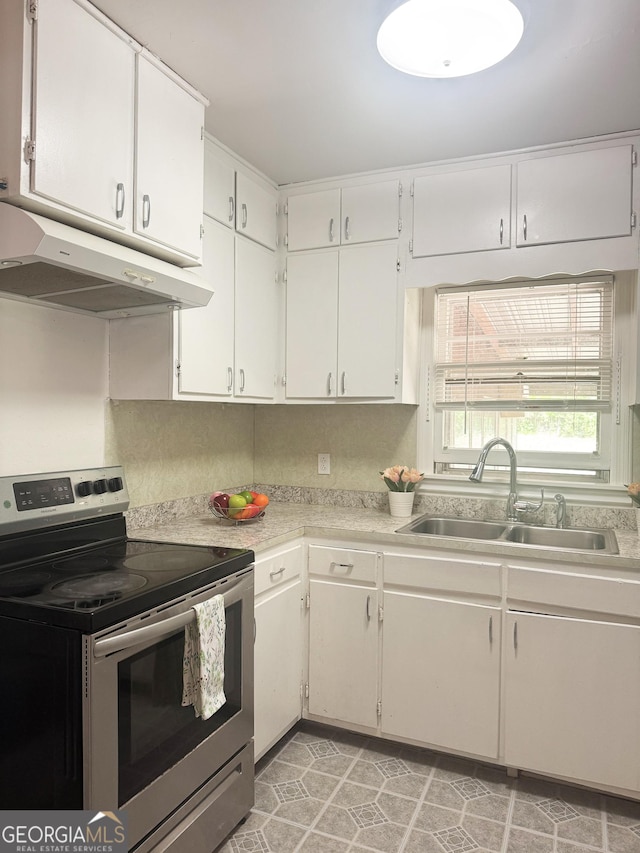 6718 Delta Dr, Riverdale, GA 30274 - kitchen featuring white cabinets, a sink, light countertops, under cabinet range hood, and stainless steel range with electric cooktop
