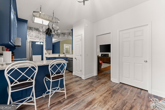 791 Thornwood Cir, Mount Airy, GA 30563 - kitchen featuring blue cabinets, stainless steel appliances, a sink, light countertops, and a peninsula