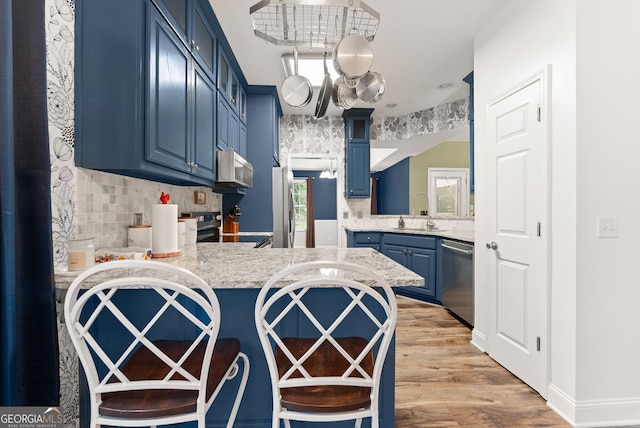 791 Thornwood Cir, Mount Airy, GA 30563 - kitchen with blue cabinets, appliances with stainless steel finishes, a sink, light countertops, and backsplash