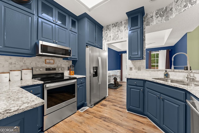 791 Thornwood Cir, Mount Airy, GA 30563 - kitchen featuring appliances with stainless steel finishes, a sink, blue cabinetry, light countertops, and tasteful backsplash