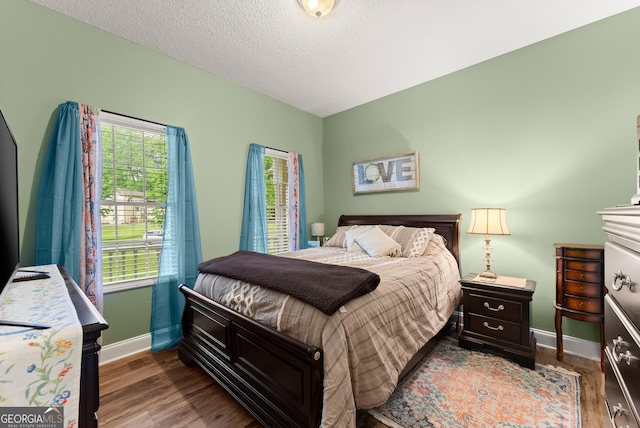 791 Thornwood Cir, Mount Airy, GA 30563 - bedroom with baseboards, wood finished floors, multiple windows, and a textured ceiling