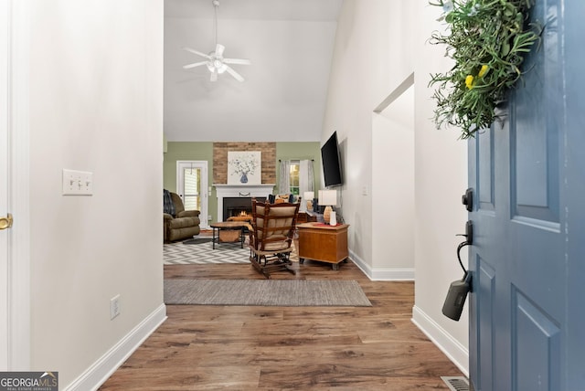 791 Thornwood Cir, Mount Airy, GA 30563 - foyer with high vaulted ceiling, baseboards, a large fireplace, wood finished floors, and a ceiling fan