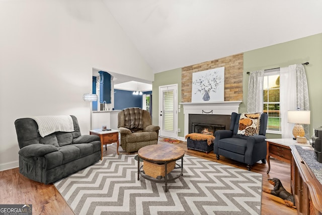 791 Thornwood Cir, Mount Airy, GA 30563 - living area featuring a warm lit fireplace, wood finished floors, high vaulted ceiling, and baseboards