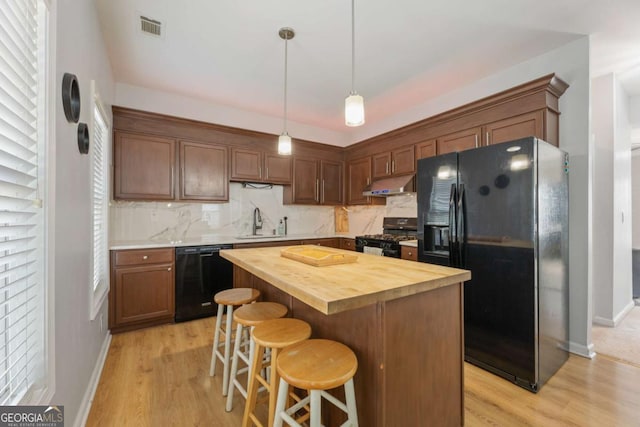 745 Abbotts Mill Ct, Duluth, GA 30097 - kitchen with black appliances, under cabinet range hood, a sink, wooden counters, and light wood finished floors