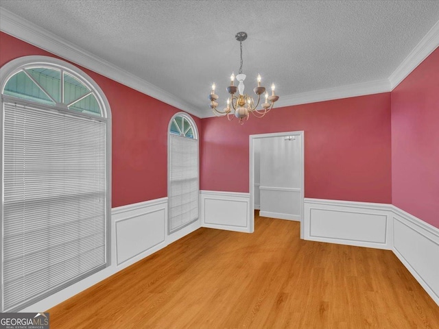 485 Fussell Rd, Leesburg, GA 31763 - unfurnished dining area featuring wainscoting, a notable chandelier, a textured ceiling, and wood finished floors