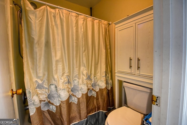 full bathroom featuring toilet and a shower with shower curtain