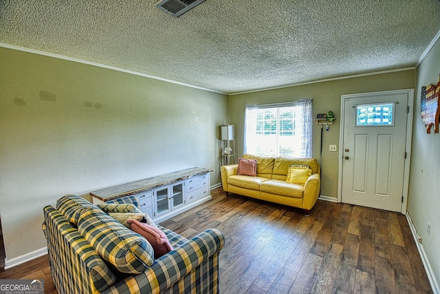 living area with hardwood / wood-style flooring, visible vents, a textured ceiling, and ornamental molding