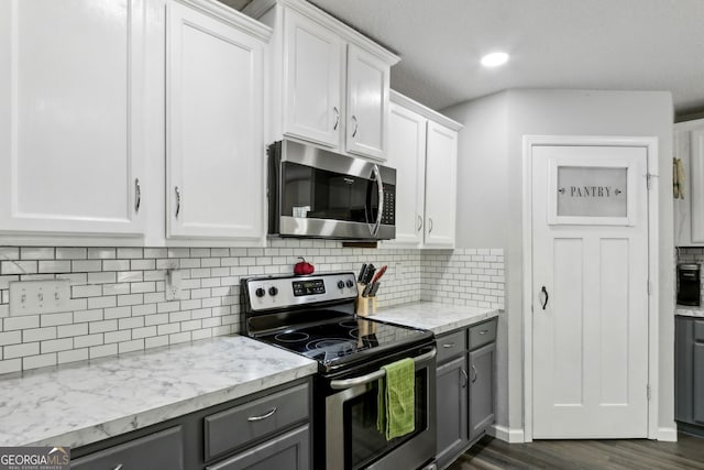 kitchen featuring tasteful backsplash, white cabinets, appliances with stainless steel finishes, dark wood-style floors, and gray cabinetry